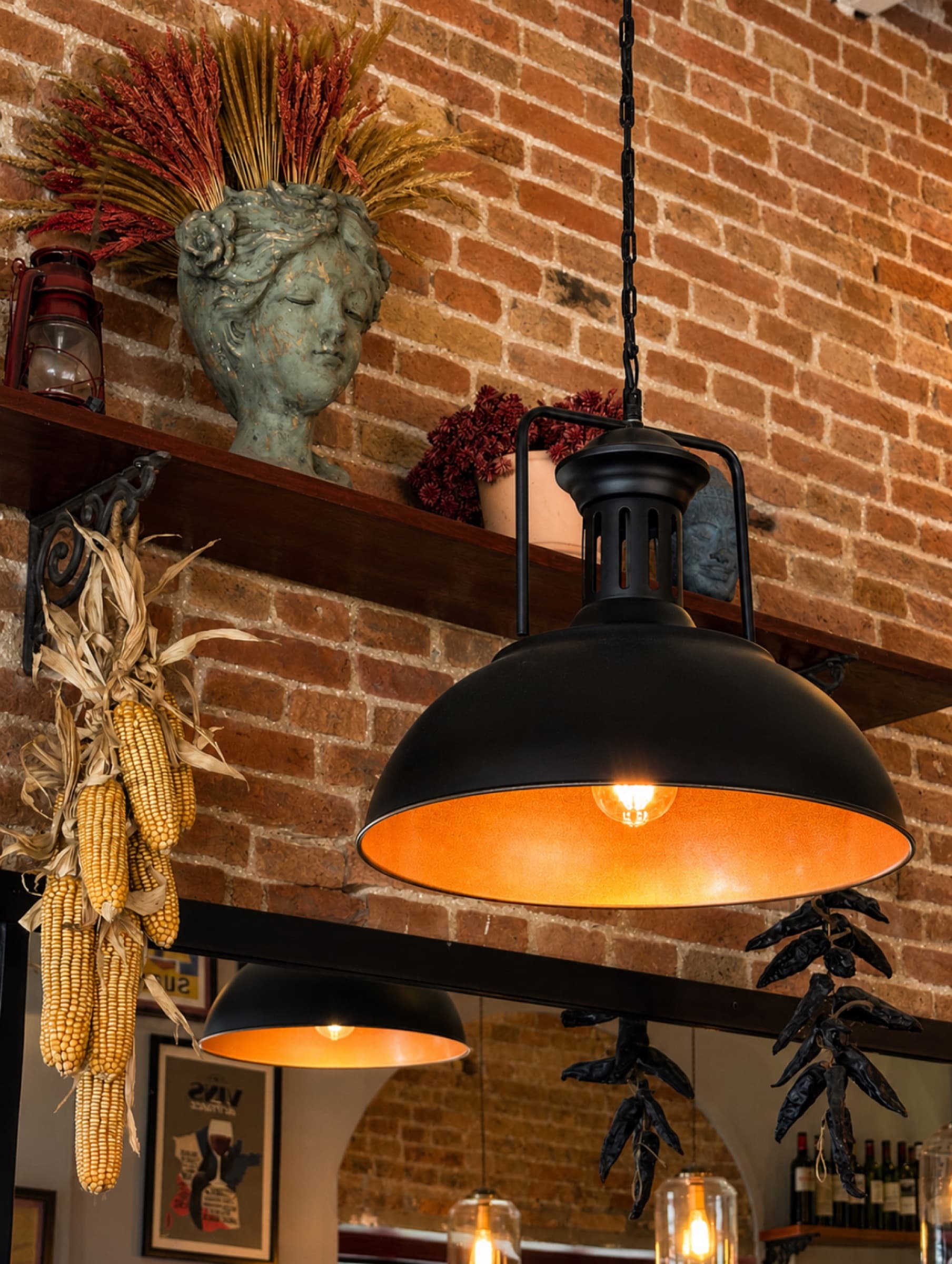 Warm pendant lighting over exposed brick inside Somaha
